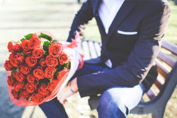 Man met bos bloemen op bankje